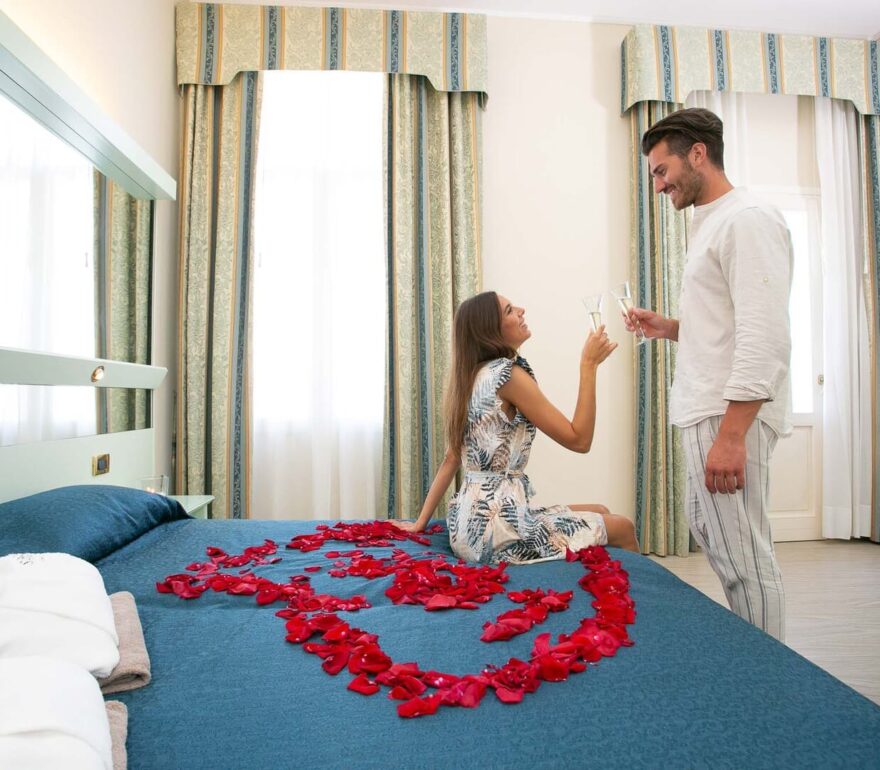Camera con petali di rosa e brindisi