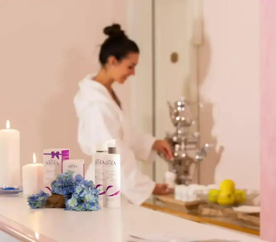 Donna in spa con candele e prodotti di bellezza.