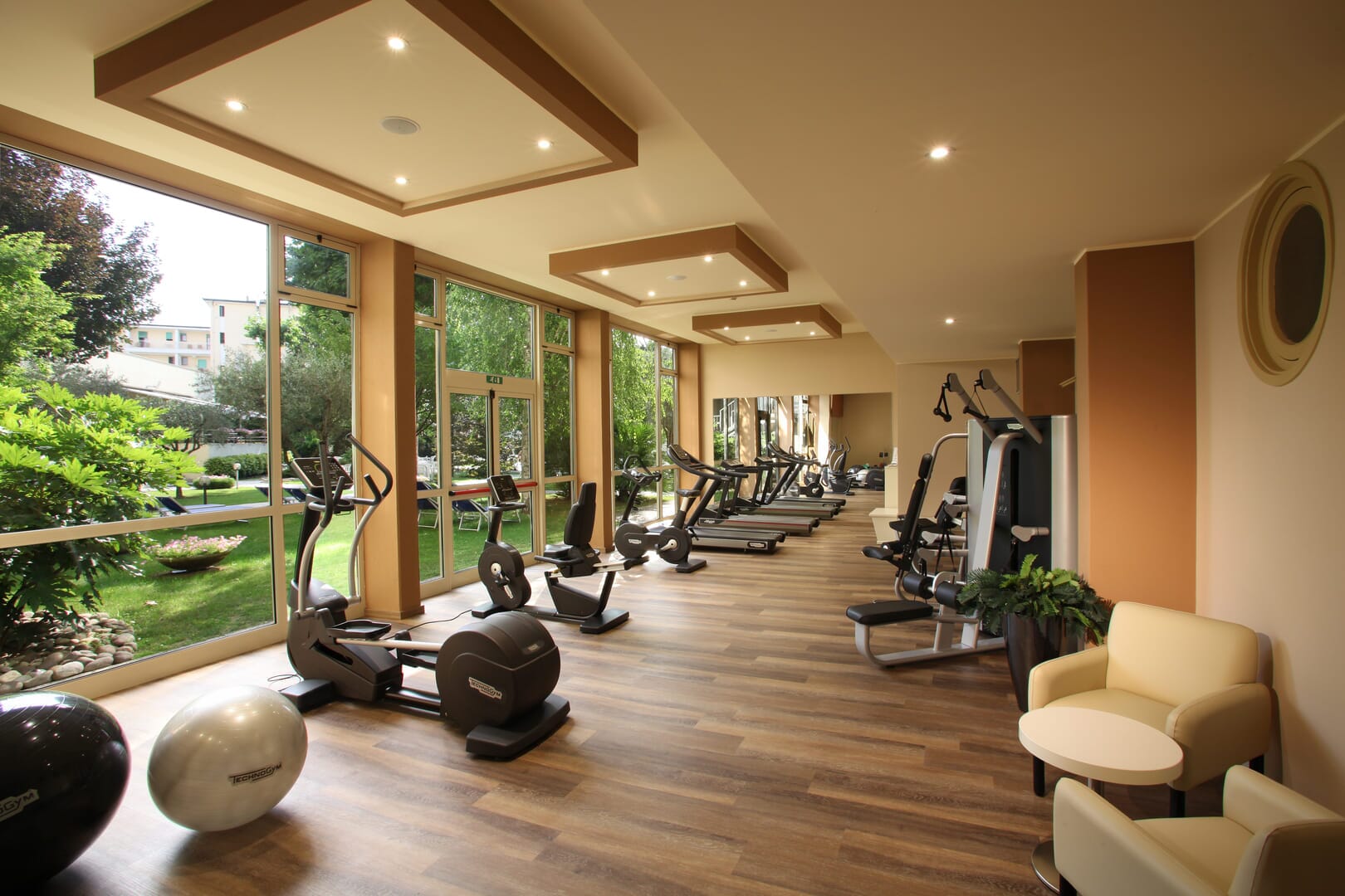 A modern gym with a view of the green garden.