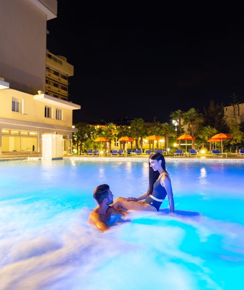 Coppia nella piscina termale notturna.